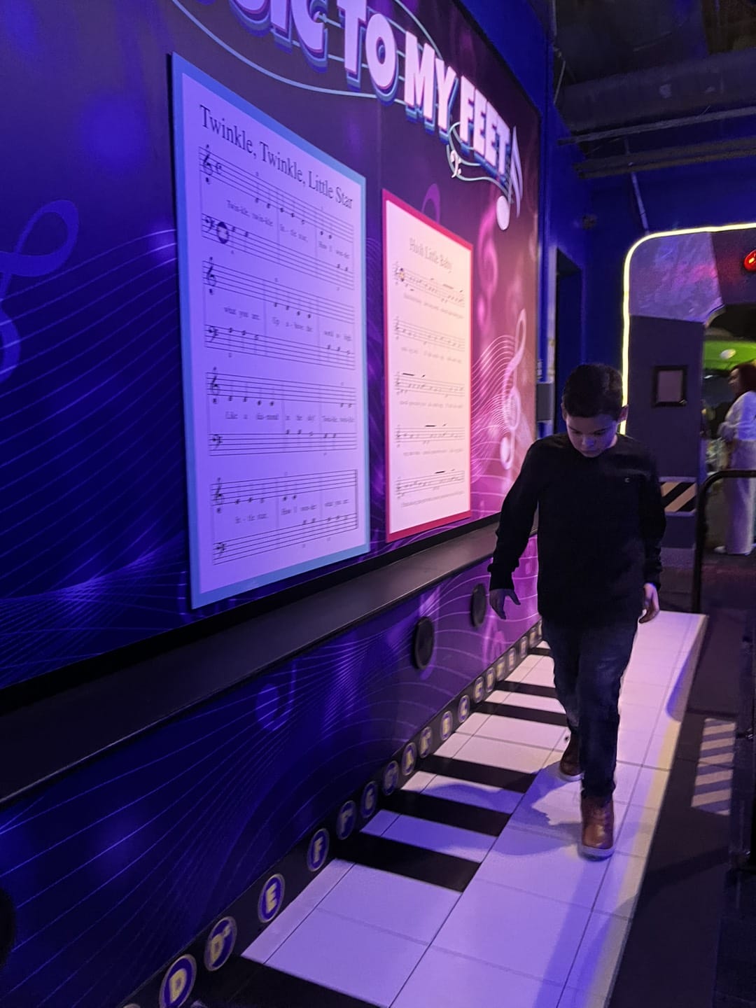 ti gason k ap mache sou yon gwo jwèt pyano